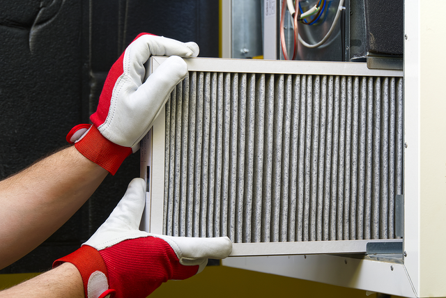Furnace Filters - View of a technician installing an air filter in a furnace, demonstrating its importance for furnace efficiency.