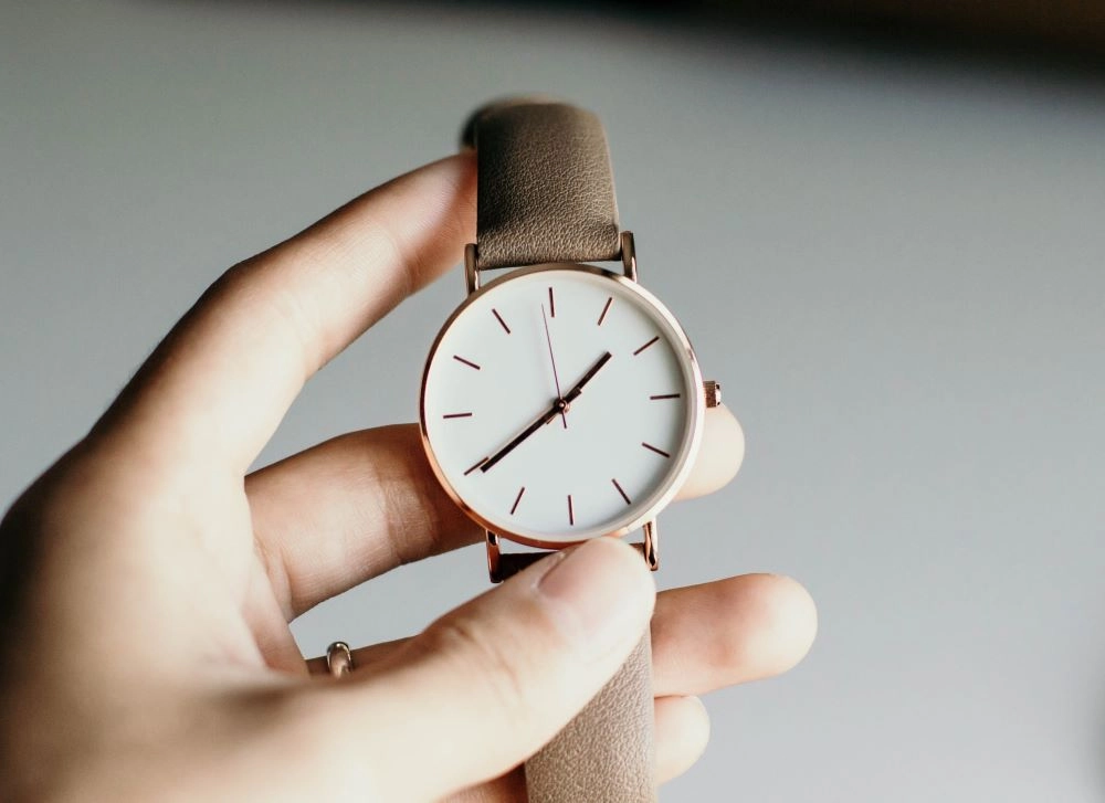 Image of a woman's hand holding a wrist watch.