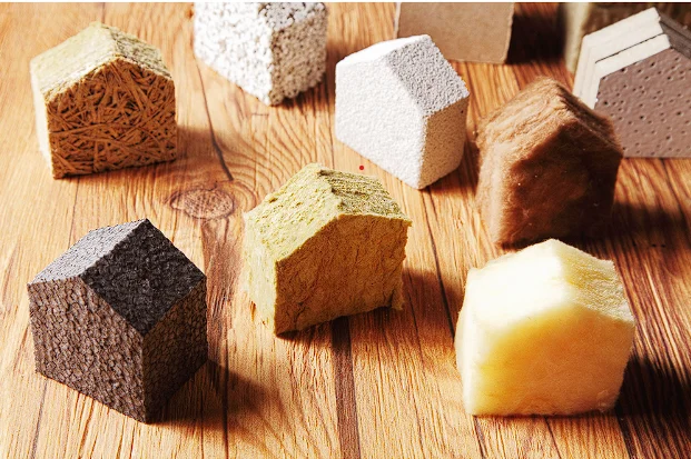 View of various attic insulation materials, including fiberglass, mineral wool, foam board, and cellulose, displayed on wood.