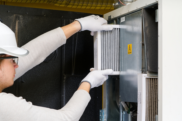 Furnace Filters - View of a person handling an air filter for furnace maintenance, highlighting its role in improving air quality.