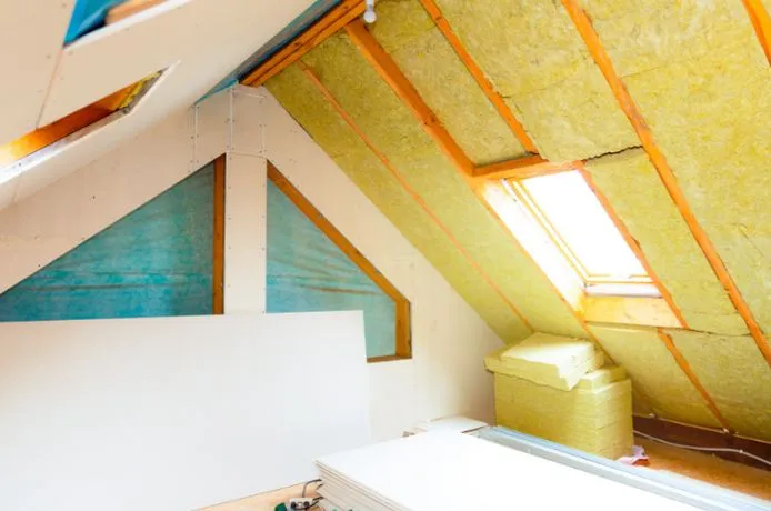 View of ongoing attic insulation using thick slabs of insulation material.