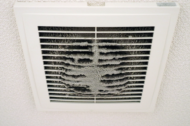 View of a dusty ceiling vent, emphasizing the importance of duct sealing to improve airflow and air quality.