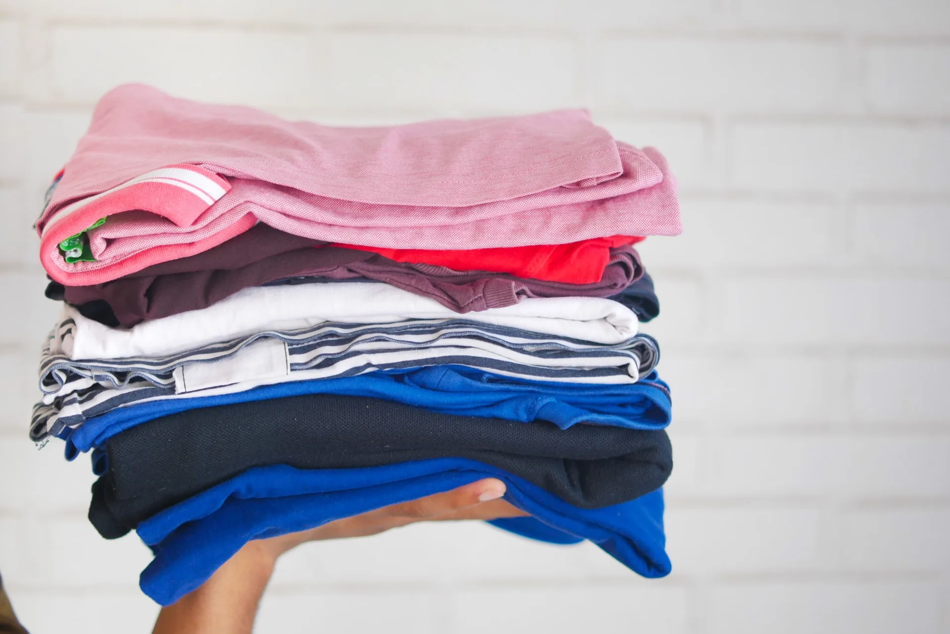 Stack of folded, multi-colored clothing.