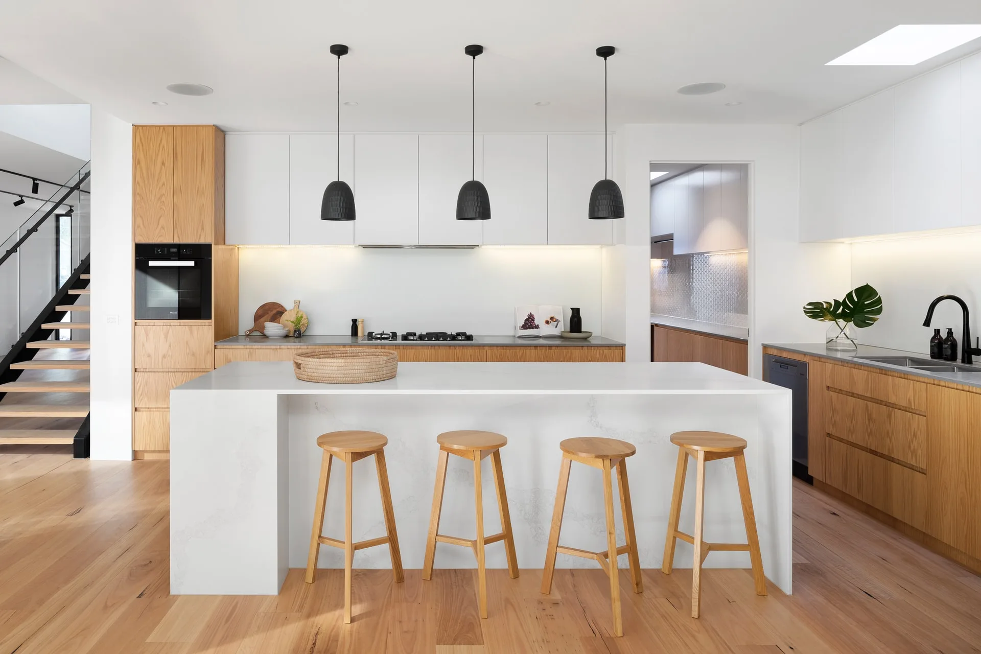Clean kitchen with island and stools.