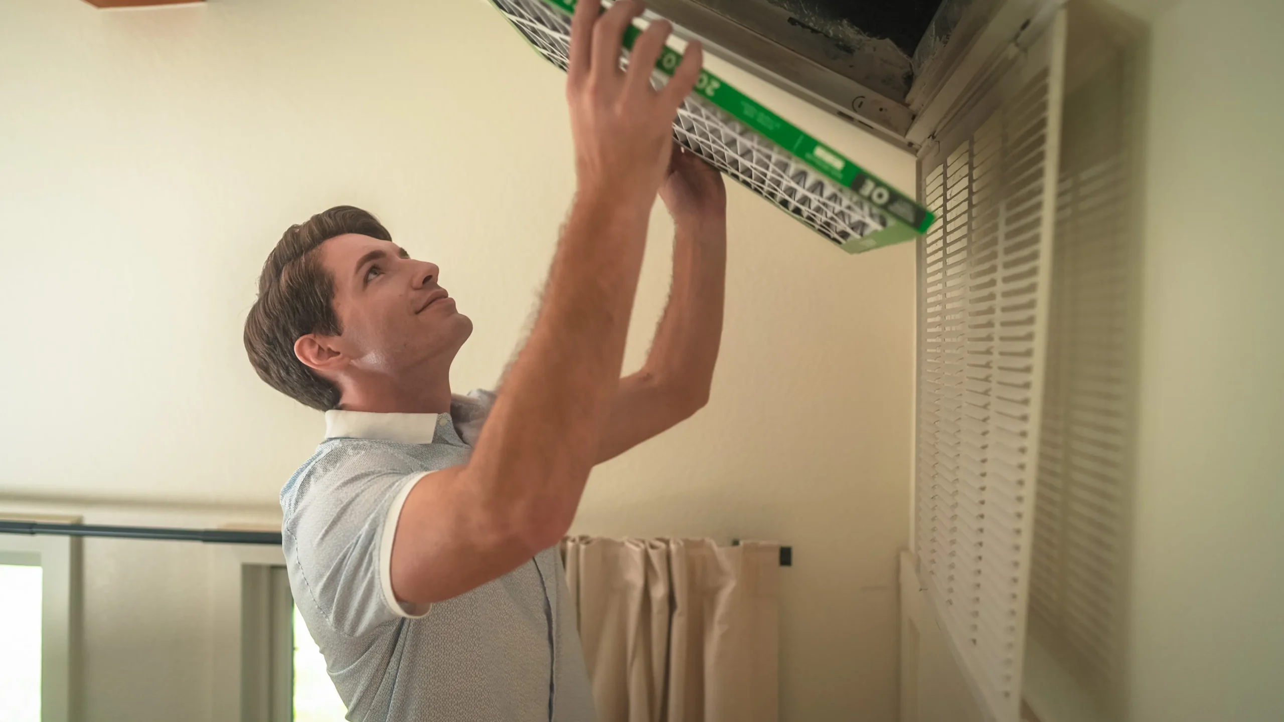 View of a homeowner installing a new HVAC air filter.