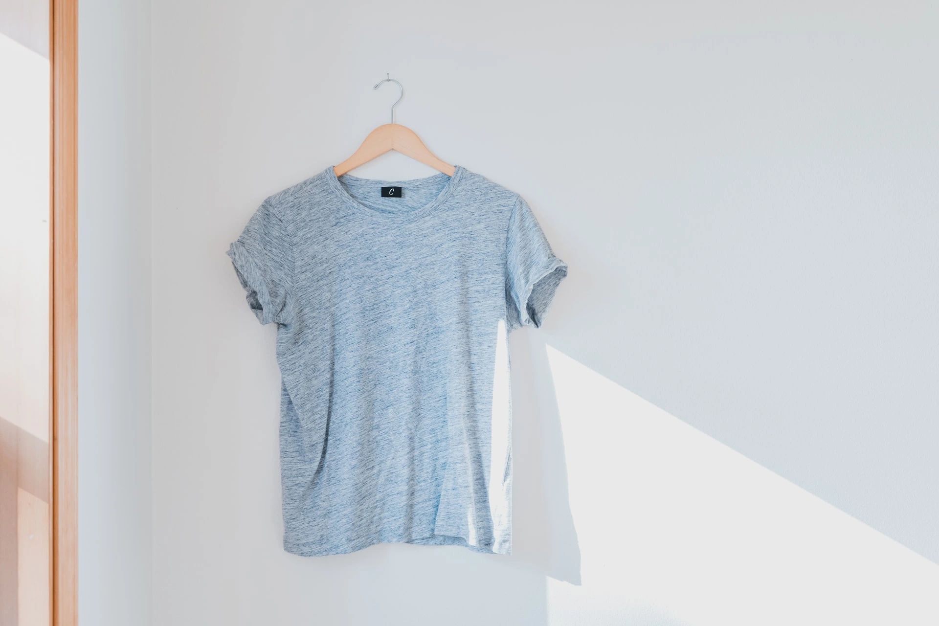 Long sleeve shirt hanging on white wall.