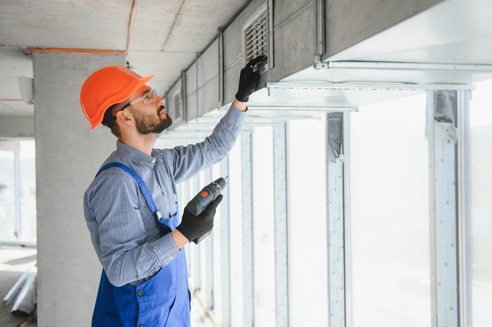A view of a technician inspecting HVAC ducts during a professional air duct cleaning service.