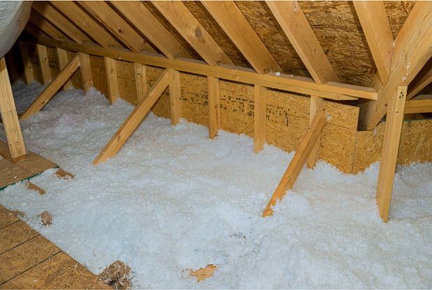 View of an attic with loose-fill insulation installed for energy efficiency and temperature control.
