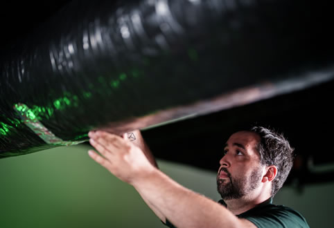 View of a Filterbuy technician carefully inspecting a homeowner's air duct at home for thorough and professional cleaning.