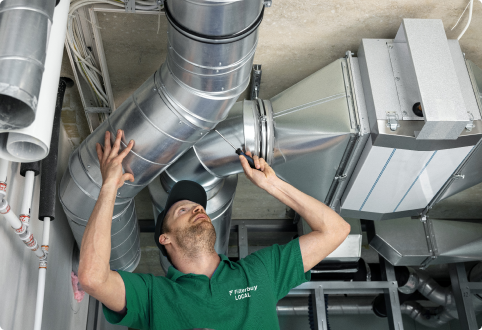 View of a Filterbuy technician carefully inspecting and doing the necessary repair the ductwork.