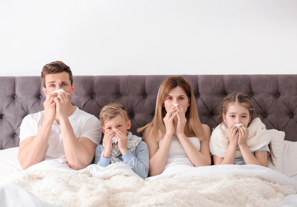 an image of a family sick in bed due to poor indoor air quality from bacteria in the HVAC system