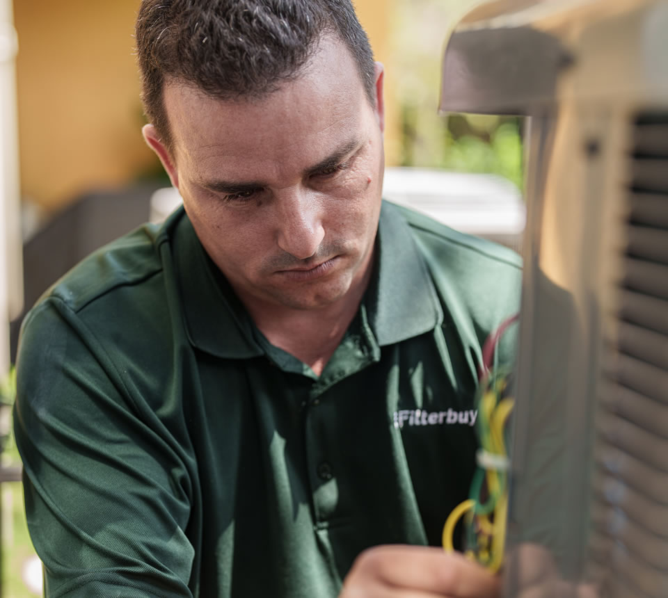 Image of a Filterbuy professional technician carefully conducting a 24-hour emergency furnace repair on an HVAC unit.