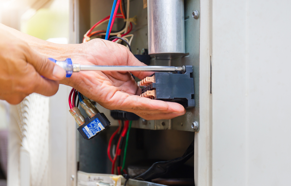 Close-up of a technician performing AC repair service, showcasing hands-on maintenance to keep your air conditioner running efficiently and your home cool.