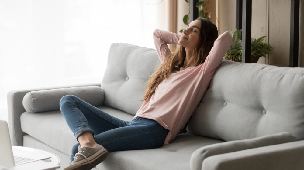 An image of a relaxed woman enjoying clean indoor air representing the benefits of safely sealing air ducts yourself for improved comfort and efficiency