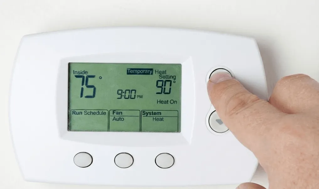 View of thermostat display showing auxiliary heat turned on with no warm air blowing, illustrating a common heating system issue and thermostat troubleshooting scenario.