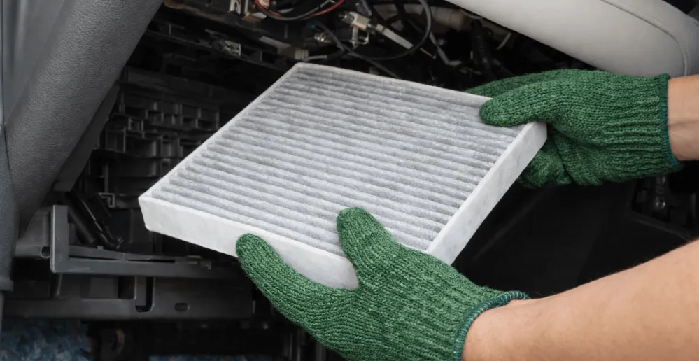 View of car AC cabin air filter replacement process with technician